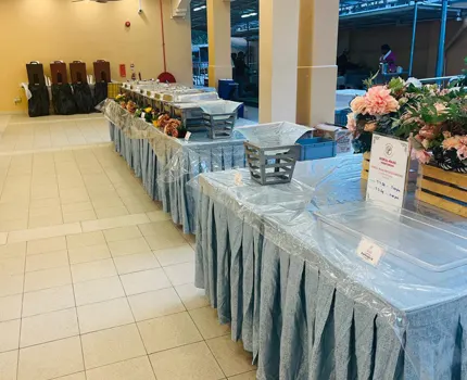A buffet set up by the best catering service in Singapore, featuring elegant blue draped tables and silver food trays. 